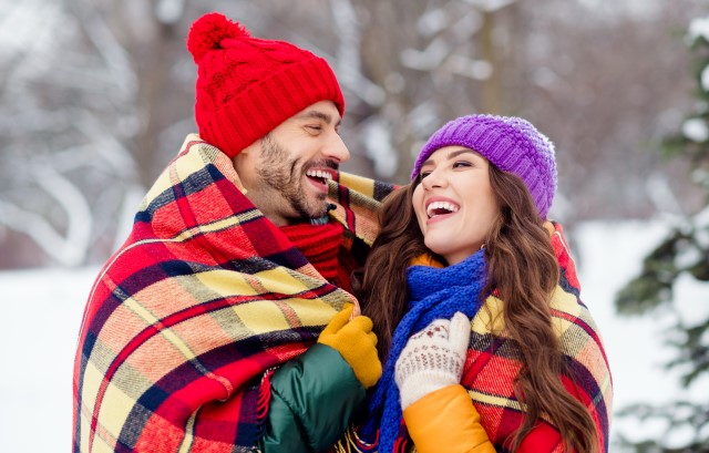 雪の中で笑い合うカップル