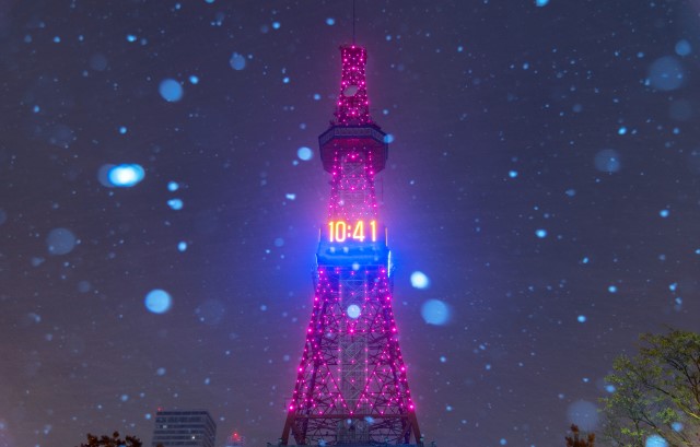 雪の舞う中ピンクにライトアップされたさっぽろテレビ塔