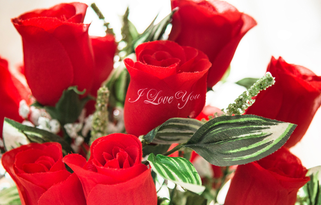 花びらに「I LOVE YOU」とプリントされた赤いバラの花束