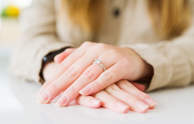 左手薬指に婚約指輪を付けている女性