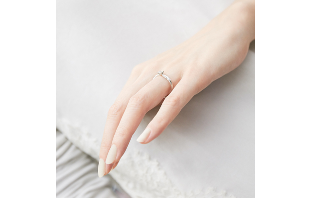 立て爪タイプの婚約指輪をつけた手