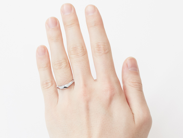 ラインがV字の結婚指輪を着用した手