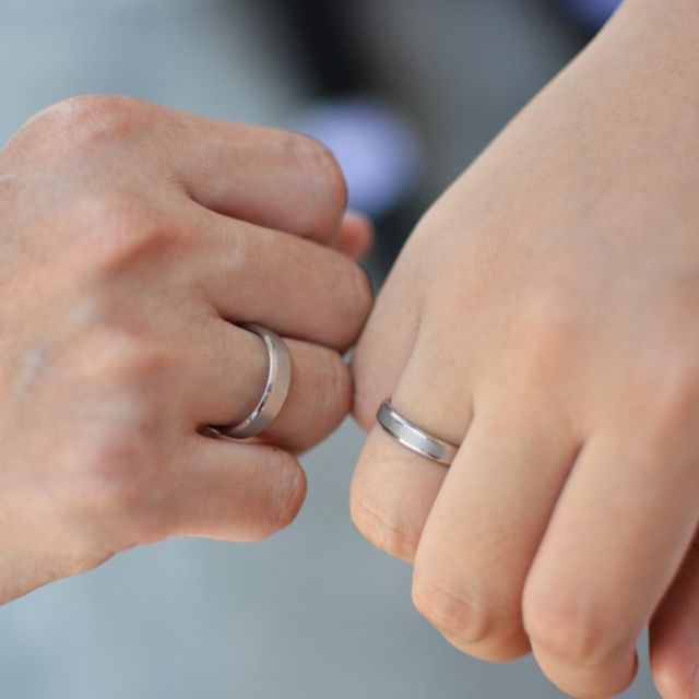 婚約指輪をつけている夫婦の手