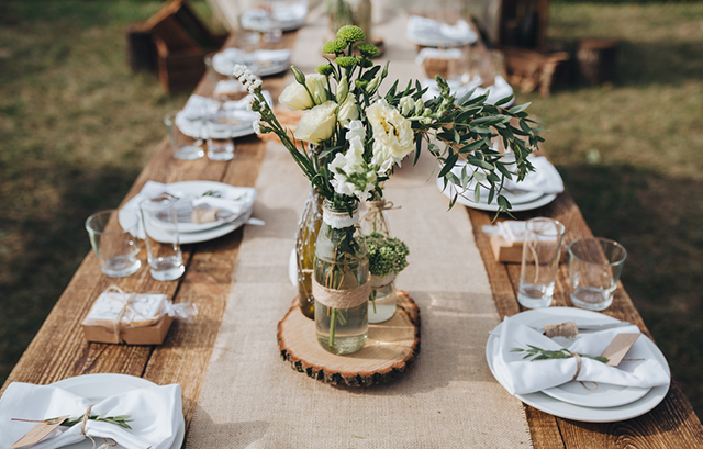 中央に白い花とグリーンの花瓶が置かれた木の流しテーブル