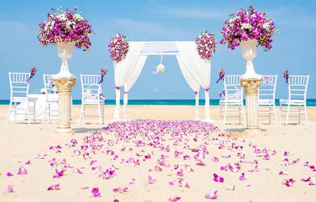 バージンロードに生花が使われた砂浜の挙式会場