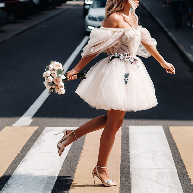ミニ丈のウェディングドレスを着て駆ける花嫁