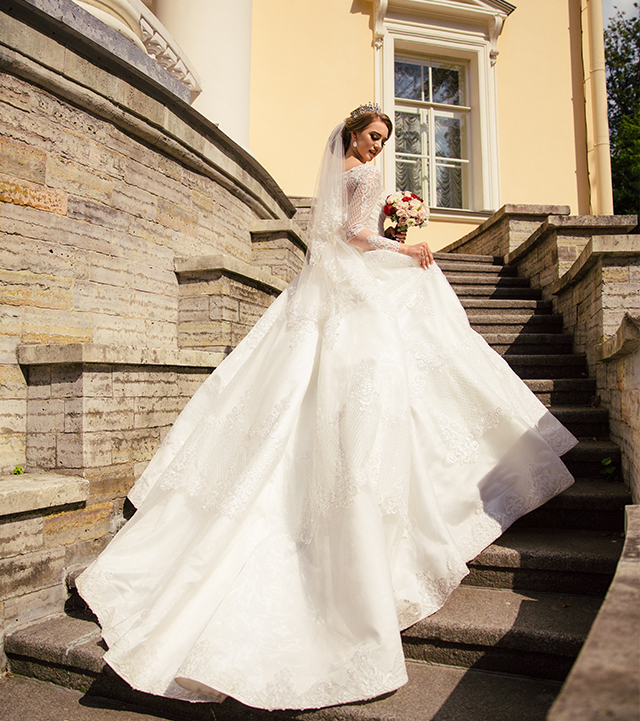 屋外の階段でふんわりとしたトレーンをなびかせる花嫁