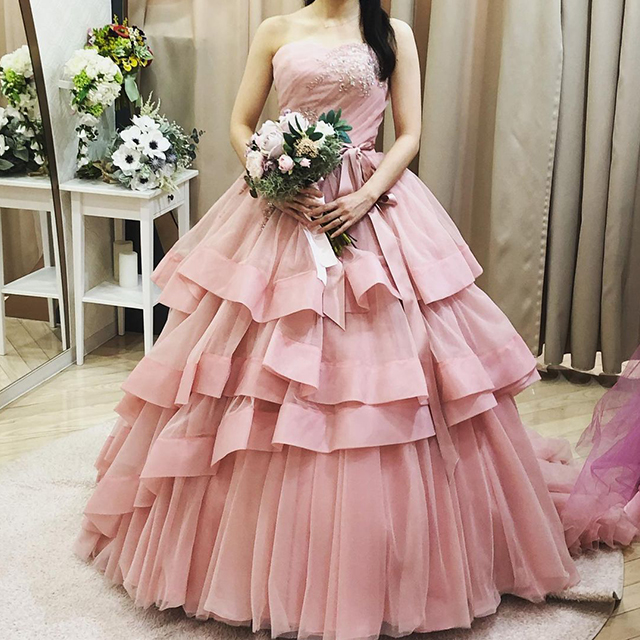 くすみピンクのドレスを着た女性