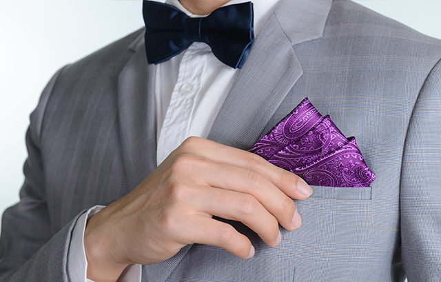 濃紺の蝶ネクタイと紫のポケットチーフの着用例