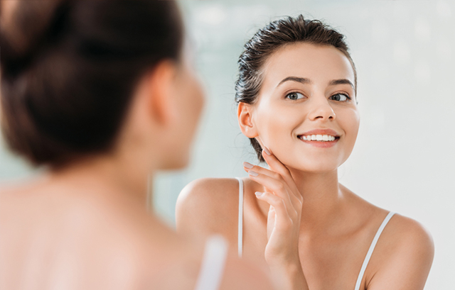 鏡で肌を確認する女性