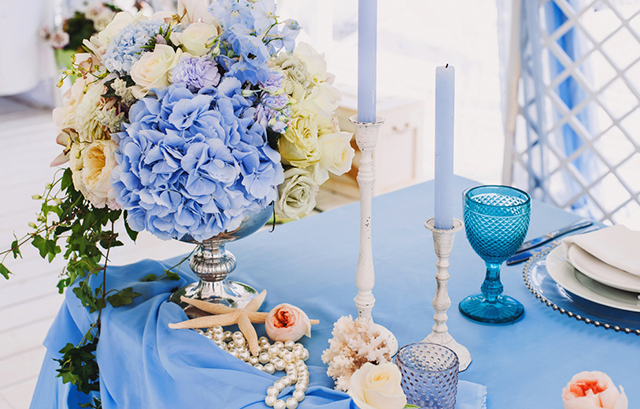 淡いブルーと白の装花が飾られたテーブル