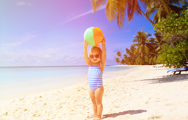 砂浜に立っているボールを持った女の子