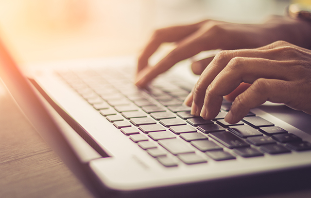 ノートパソコンを叩く手