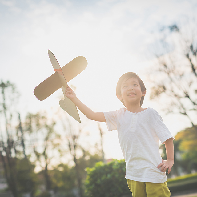 紙飛行機を持つ子供
