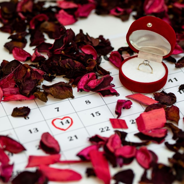 花びらと婚約指輪が置かれたカレンダー