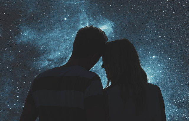 満天の星空を眺めながら頭を寄せ合うカップル