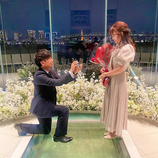 夜景の見えるチャペルでプロポーズしているカップル