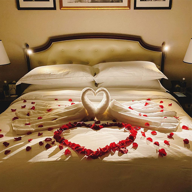 バラの花びらで彩られたホテルのベッド