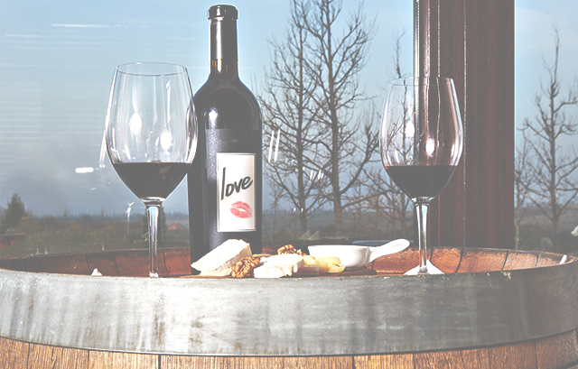 ラベルに「love」と書かれた赤ワインのボトルとワインが注がれた2つのグラス