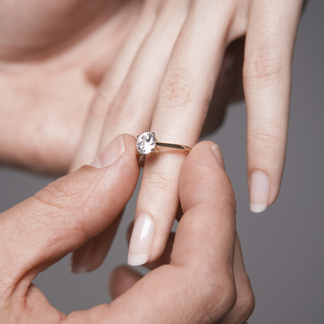男性が女性の指に婚約指輪をつける様子