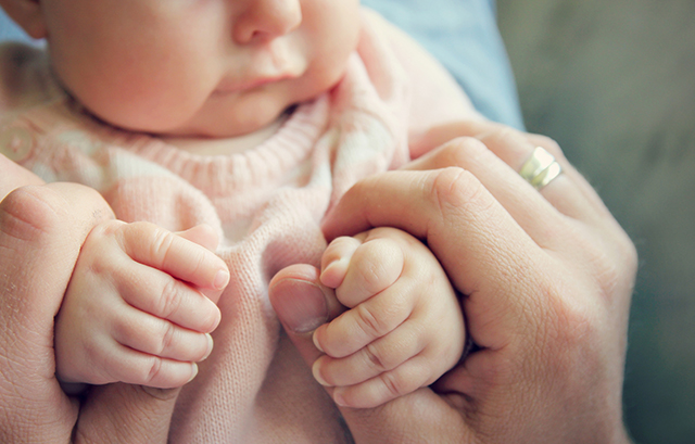 赤ちゃんの手を握っている女性