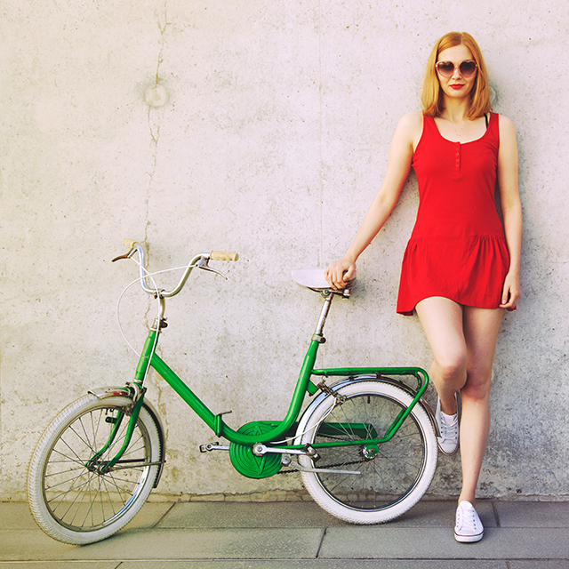 壁にもたれる女性と自転車