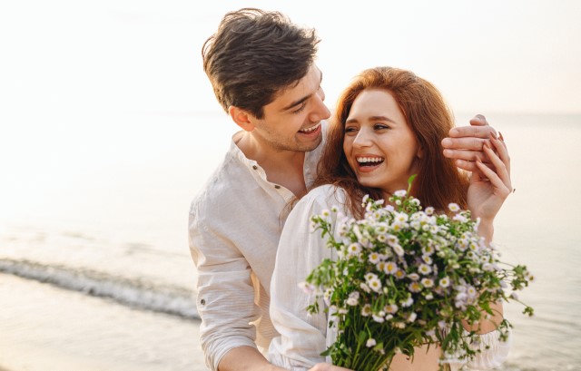 海辺で妻に花を贈る夫