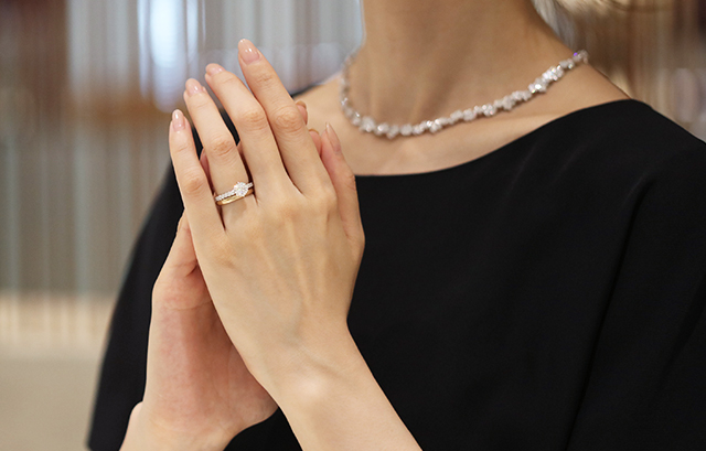 婚約指輪と結婚指輪を重ねづけしている女性の手元