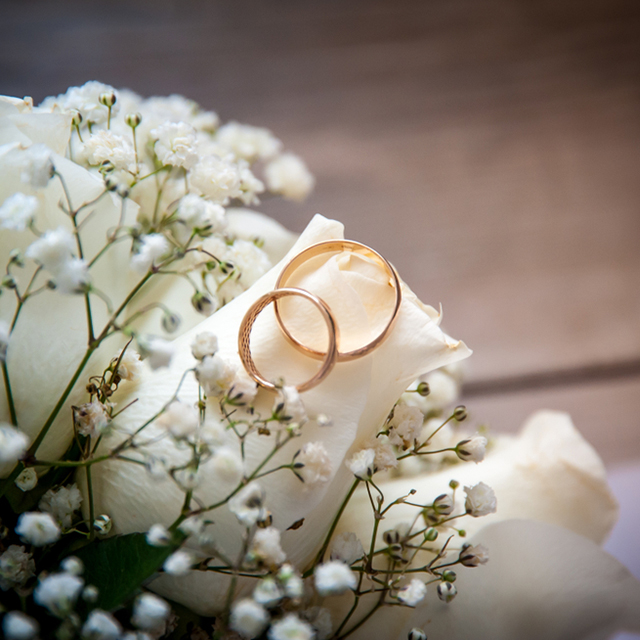 花の上に重ねて置かれた結婚指輪