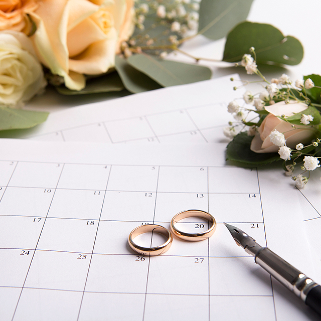 結婚指輪をのせたカレンダーと万年筆