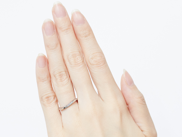 ラインがS字の結婚指輪を着用した手
