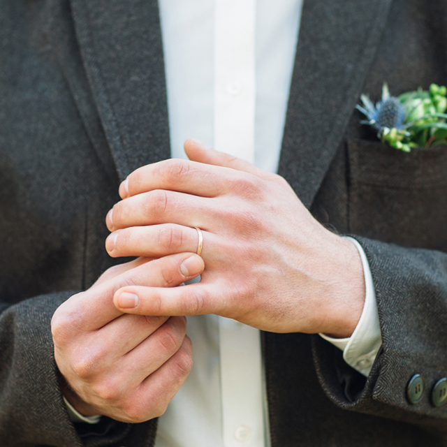 結婚指輪をつける男性の手元