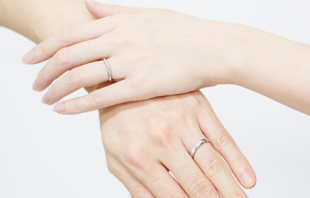 NIWAKA の結婚指輪　睡蓮（すいれん）を着用した女性の手とNIWAKA の結婚指輪　茜雲（あかねぐも）を着用した男性の手