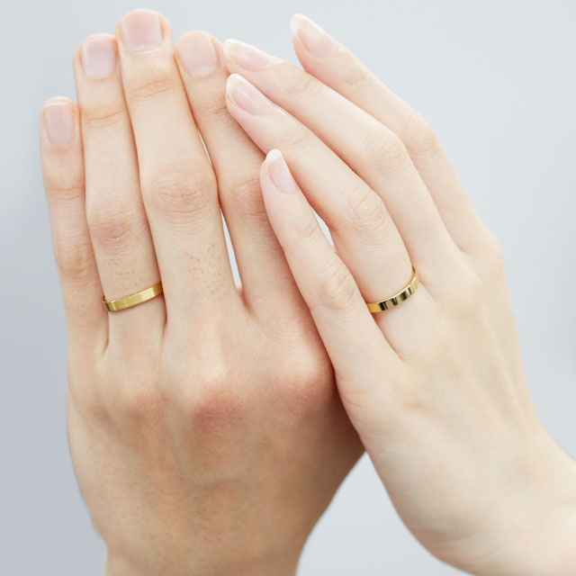 ペアの結婚指輪をつけた男女の手