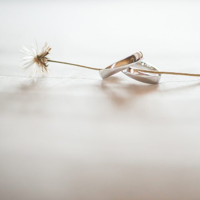 花の茎が通されたシンプルな結婚指輪