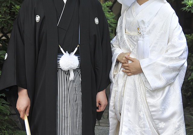 紋付羽織袴の男性と白無垢の女性