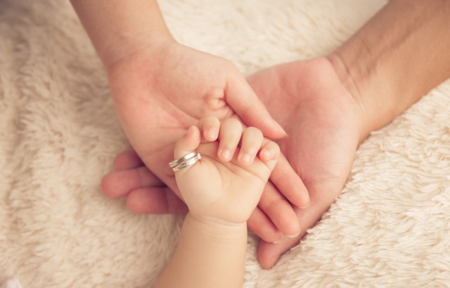 夫婦と、指輪のついた新生児の手