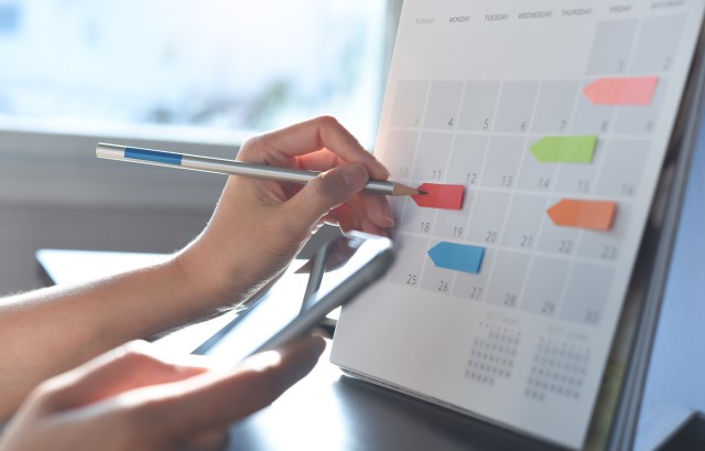 スケジュール帳にペンでメモをする様子