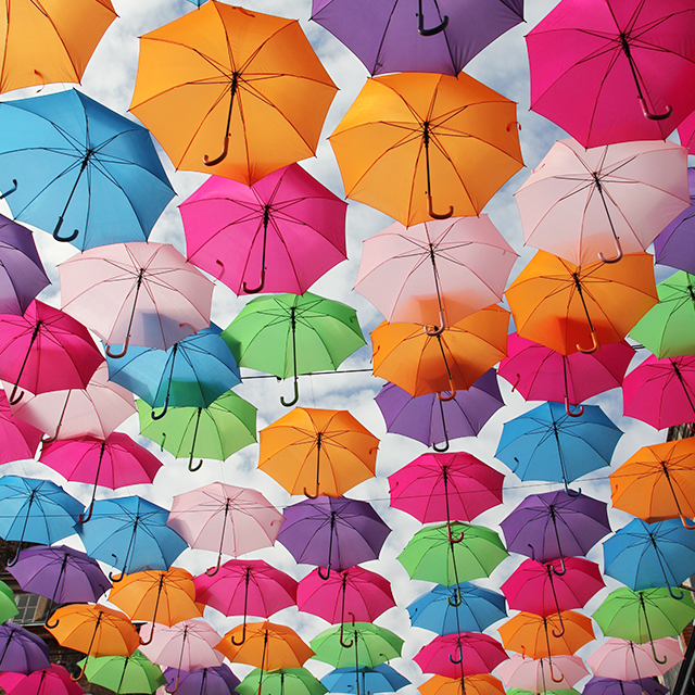 空に浮かぶ大量のカラフルな傘