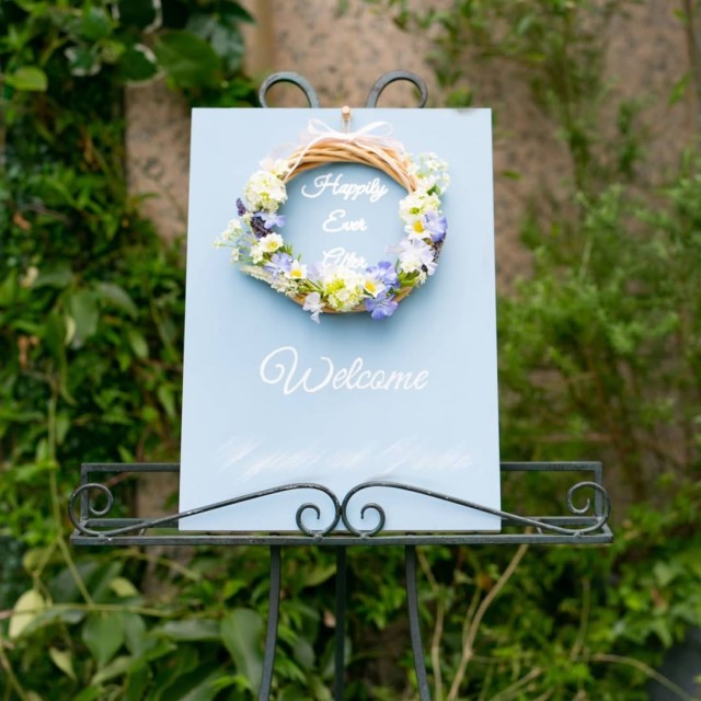 青い花を使ったリースを飾り付けたウェルカムボード