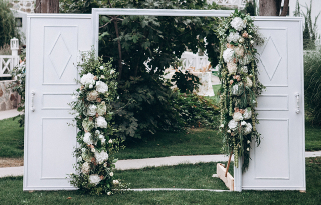 花で装飾された屋外に設置した白い扉
