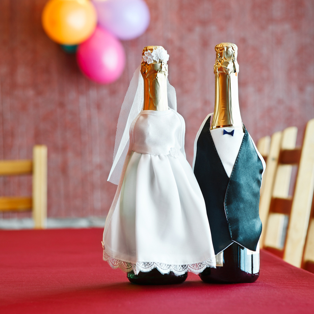 ウェディングドレスとタキシードで飾られたシャンパンボトル