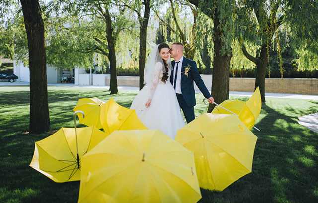 黄色の傘に囲まれる新郎新婦