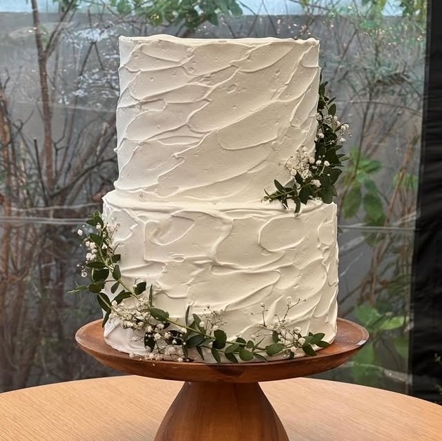 ユーカリとかすみ草があしらわれた白いウェディングケーキ