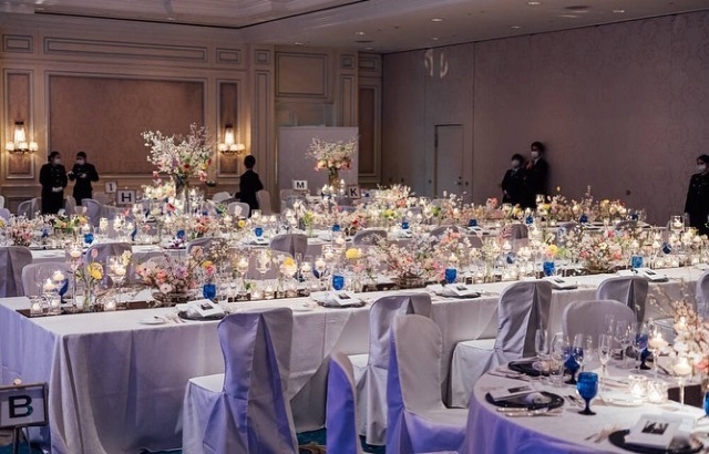 テーブルクロスと同じカラーのチェアカバーを椅子にかぶせた披露宴会場