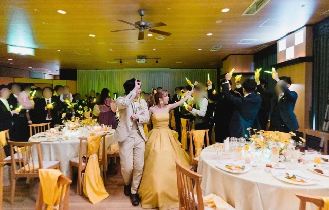 結婚式のテーマカラーのリボンを椅子に飾り付けた披露宴会場