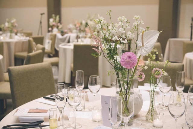 白いデルフィニウムやラナンキュラスが飾られたテーブルコーディネート