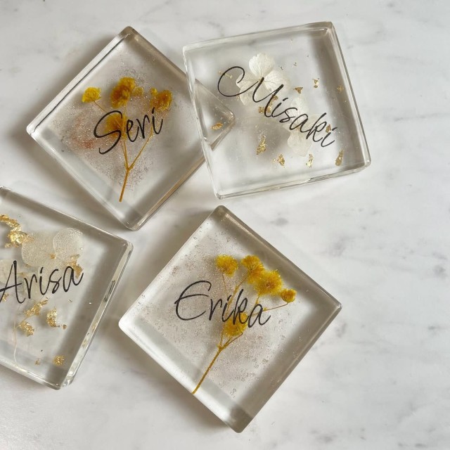 ドライフラワーをレジンで固めて作ったものに名前が書かれた席札