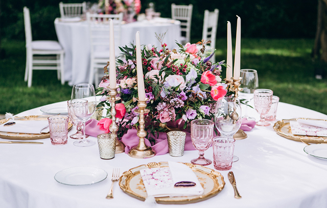 上品な装花と高級感のあるキャンドルスタンドやカトラリー、ショープレートで装飾されたゲストテーブル