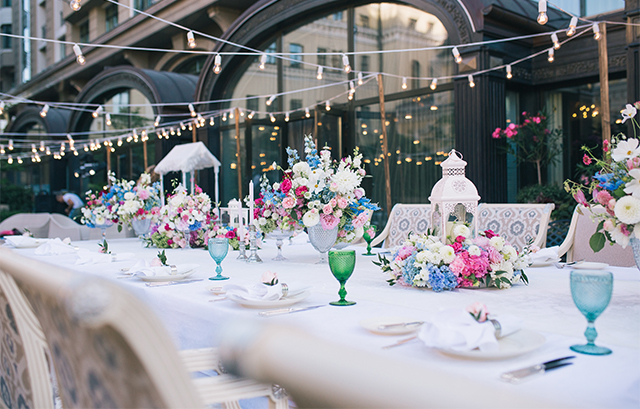ホワイトのクロスがかけられたテーブルにカラフルな装花やグラスが並ぶ様子